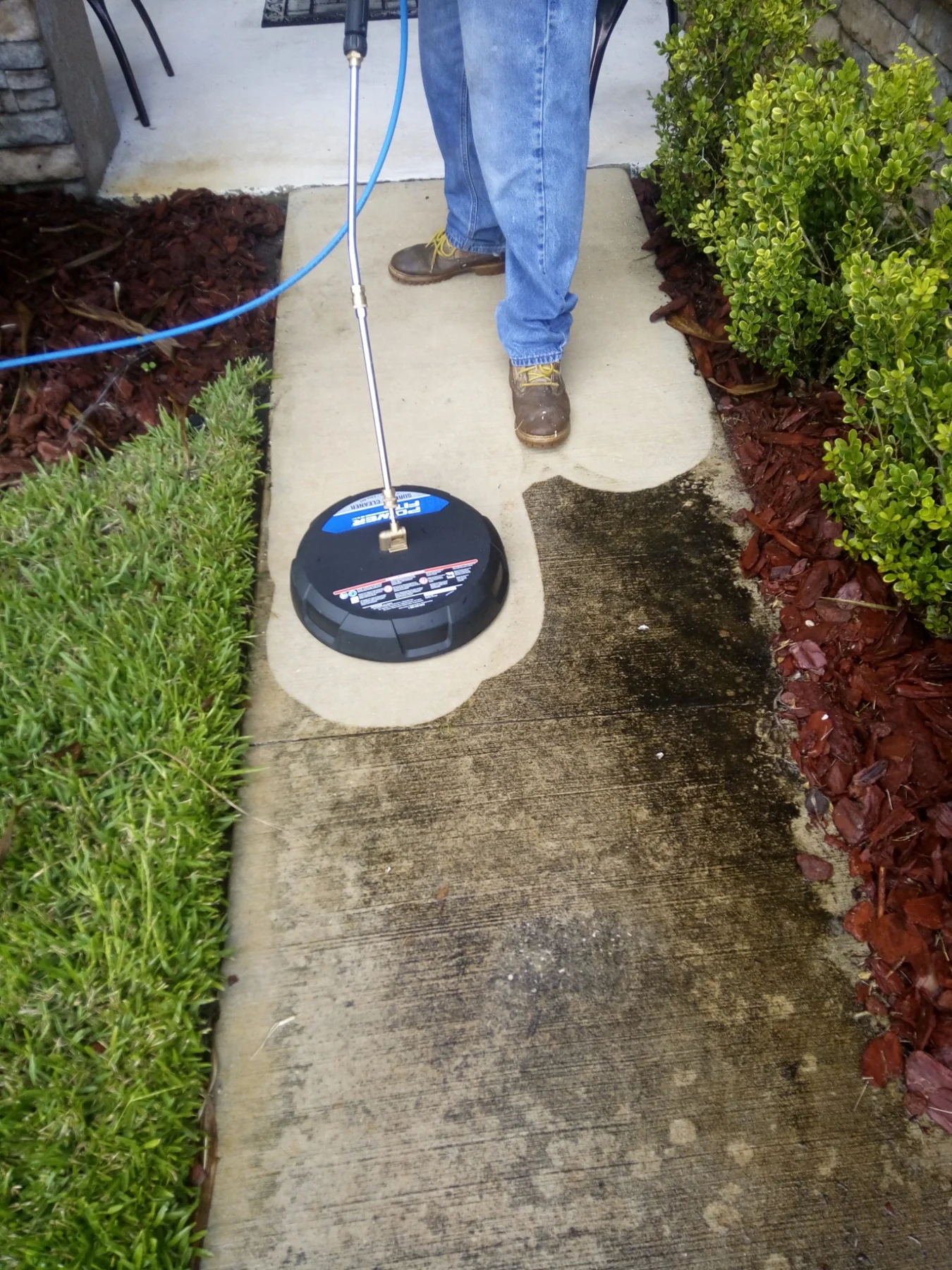 Surface cleaner removing dark buildup from a concrete front walkway